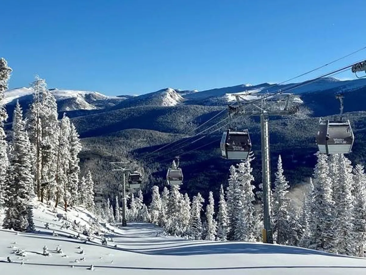 A breathtaking view featuring ski lift gondolas gliding over snow-covered trees and a dramatic mountain range in the background. The scene is serene yet adventurous, with golden sunrise light hinting at early ski runs and endless mountain exploration.